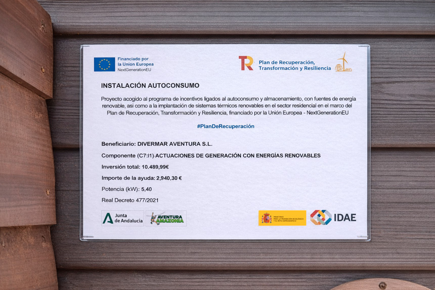 Cartel informativo de instalación de autoconsumo energético financiado por la Unión Europea colocado en una pared de madera